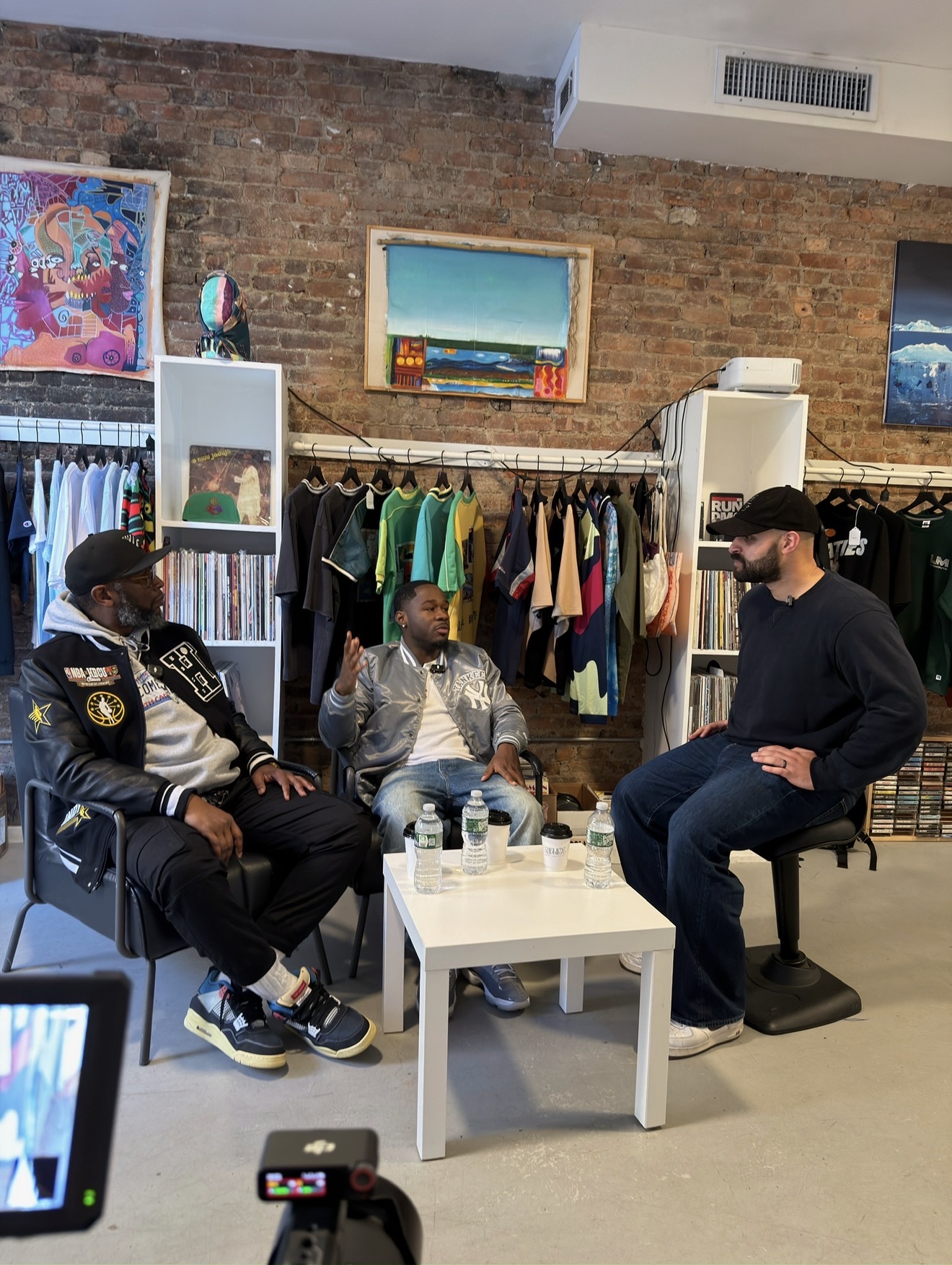 Ahmad interviewing two artists in a vintage record and clothing shop